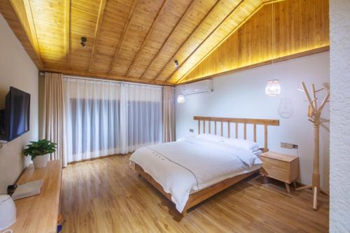 a bedroom with a large bed and a wooden ceiling at Hongfu Villa - Zhangjiajie National Forest Park West Gate in Zhangjiajie