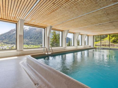 a swimming pool in a building with windows at Apartment Guardaval - Utoring-36 by Interhome in Davos