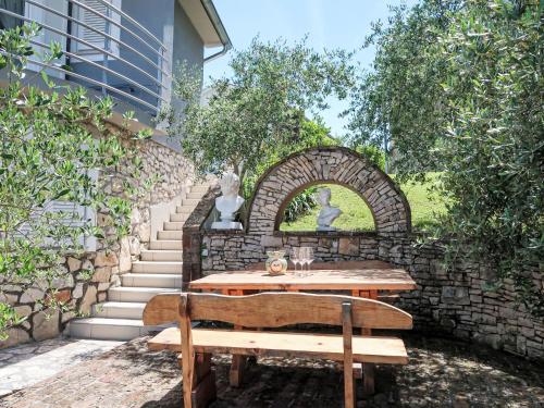 a wooden bench sitting in front of a stone wall at Holiday Home Diana by Interhome in Kršan