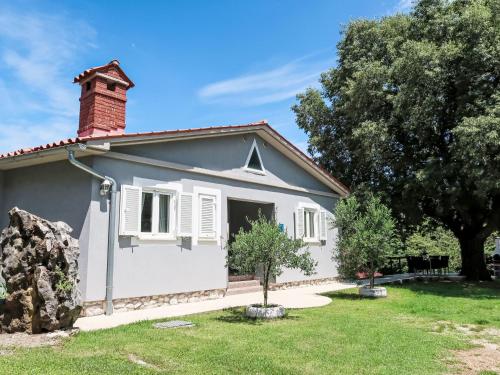 a small white house with a brick chimney at Holiday Home Diana by Interhome in Kršan