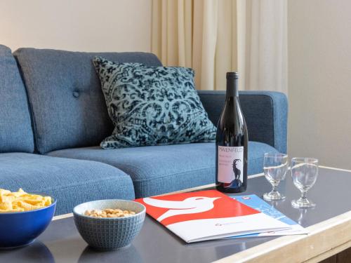 a bottle of wine sitting on a table next to a couch at Apartment Parkareal - Utoring-24 by Interhome in Davos