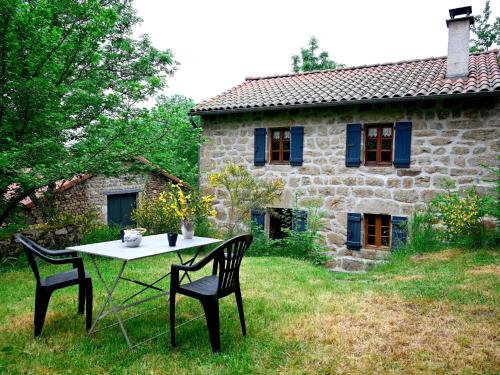 une table et des chaises devant une maison en pierre dans l'établissement Holiday Home L'Assemblée by Interhome, à Vielprat