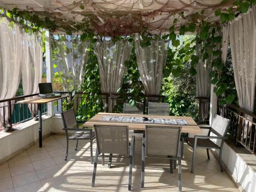 Una mesa y sillas en un balcón con plantas. en Aпартамент в Созопол, en Sozopol