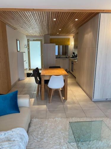 un salon avec une table et une cuisine dans l'établissement Le Lion d'Or 6, joli T3 en plein centre de Châtel - Multipass inclu, à Châtel