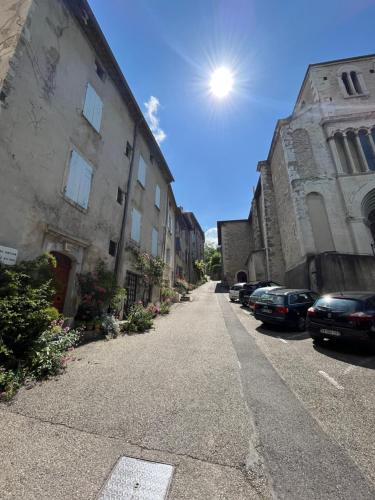 an empty street with cars parked next to buildings at Maison La vieille vigne in Dieulefit