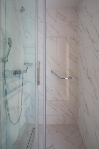 a bathroom with a shower with a glass door at Orbi City Hotel Official D Block in Batumi
