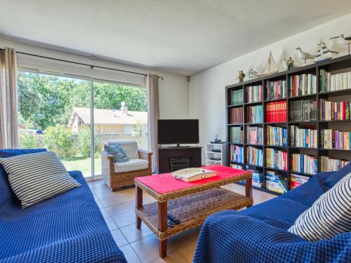 - un salon avec deux canapés bleus et une télévision dans l'établissement Holiday Home Mimosa by Interhome, à Soulac-sur-Mer