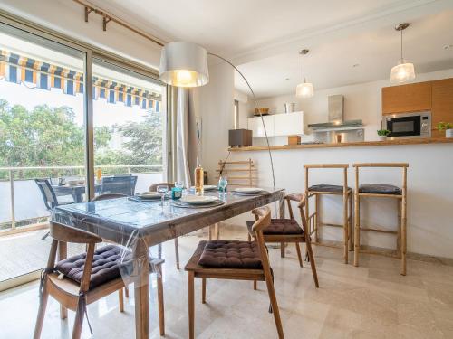 une cuisine et une salle à manger avec une table et des chaises dans l'établissement Apartment Les Aliscamps by Interhome, à Cannes