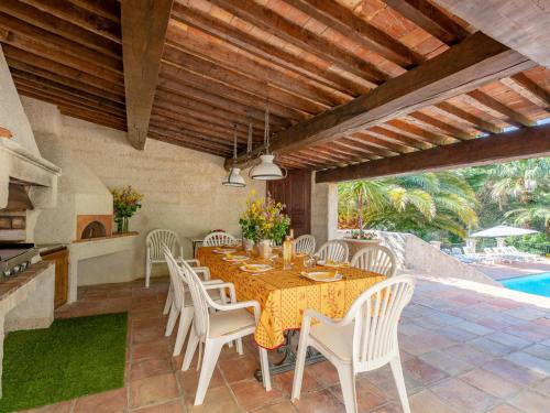 a dining room with a table and white chairs at Holiday Home L'Oliverede by Interhome in La Garde-Freinet