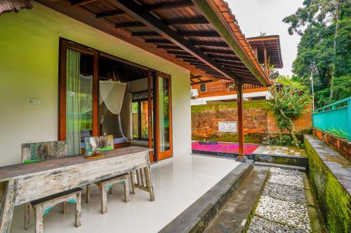 a patio of a house with a wooden bench at Ubud Sawah Scenery Villa and Homestay in Tegalalang