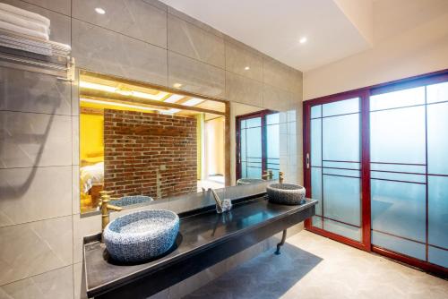 a bathroom with two sinks and a mirror at Hongfu Villa - Zhangjiajie National Forest Park West Gate in Zhangjiajie