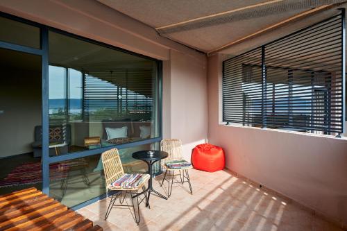 a room with a balcony with chairs and a table at Sunny Beach Club - Adults Only #YouthfulVibes in Sunny Beach