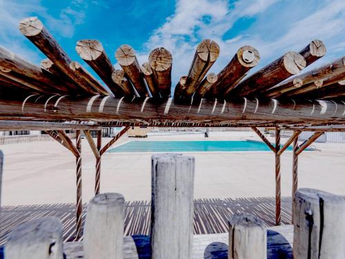 une pergola en bois avec une piscine en arrière-plan dans l'établissement Apartment Martinique 2-3-1 by Interhome, au Barcarès