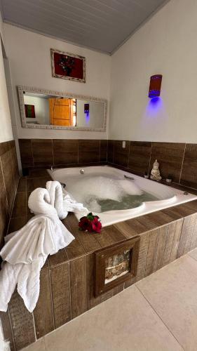 a bathroom with a tub with towels on the floor at Pousada Yanah in Pirenópolis