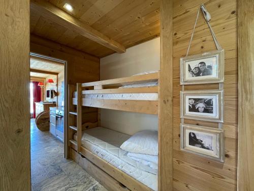 sypialnia z łóżkami piętrowymi w drewnianym domu w obiekcie Homency - Résidence Saint Laurent C1 w LʼAlpe-dʼHuez