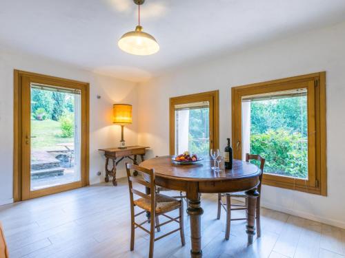 a dining room with a table and two windows at Holiday Home Policleto by Interhome in Santo Stefano A Tizzano