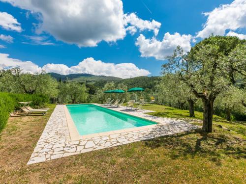 a pool with chairs and umbrellas in a garden at Holiday Home Policleto by Interhome in Santo Stefano A Tizzano