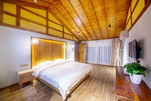 a bedroom with a large bed and a wooden ceiling at Hongfu Villa - Zhangjiajie National Forest Park West Gate in Zhangjiajie