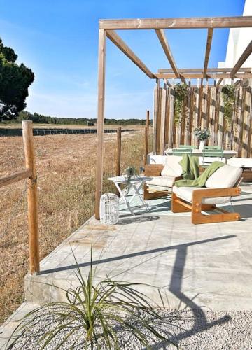 a wooden pergola with chairs and tables on a patio at Meco Lodge Private Pool Full of Grace in Sesimbra
