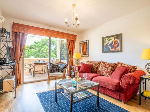 un salon avec un canapé rouge et une table dans l'établissement Apartment Le Mandarin by Interhome, à Antibes