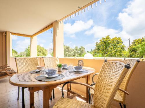d'une table et de chaises en bois sur un balcon avec une fenêtre. dans l'établissement Apartment Le Mandarin by Interhome, à Antibes