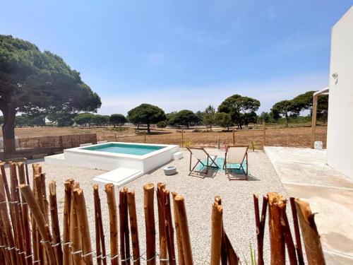 a fence with two chairs and a swimming pool at Meco Lodge Private Pool Full of Grace in Sesimbra
