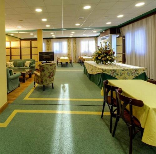 a large room with tables and chairs in a room at Hotel Suite Mioño Castro Urdiales in Castro-Urdiales