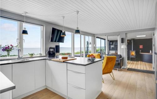 a kitchen with white cabinets and glass windows at Two-Bedroom Holiday Home In Ebeltoft in Ebeltoft