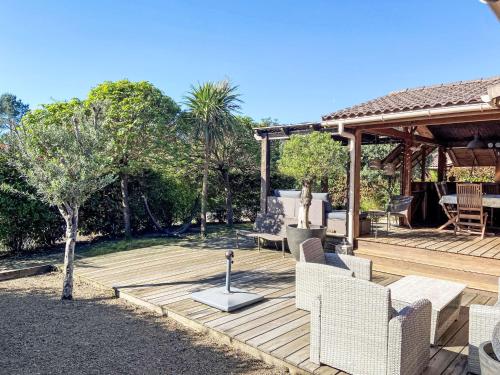 une terrasse en bois avec des chaises et un kiosque dans l'établissement Chalet Landais by Interhome, à Saubion