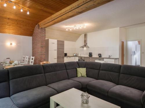 a living room with a couch and a table at Holiday Home Eifelnatur - Haus 2-4 by Interhome in Immerath