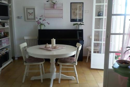 - une table et des chaises blanches dans la chambre dans l'établissement Charmant T2 CLIMATISE, avec jardins et parking privé, à Six-Fours-les-Plages