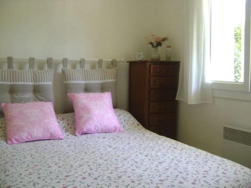 - 2 oreillers roses assis sur un lit dans une chambre dans l'établissement Charmant T2 CLIMATISE, avec jardins et parking privé, à Six-Fours-les-Plages