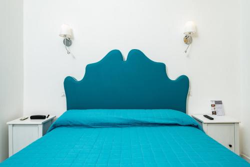 a blue bed with two night stands next to it at Hotel Fontana in Amalfi