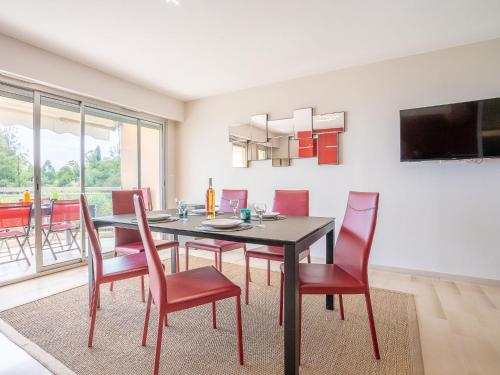 une salle à manger avec une table et des chaises rouges dans l'établissement Apartment La Croix des Gardes by Interhome, à Cannes