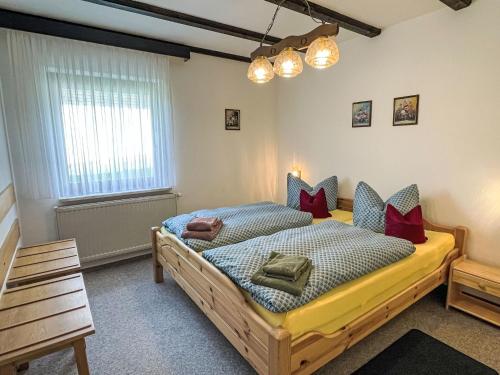 a bedroom with a large wooden bed with red pillows at Holiday Home Am Hohen Bogen-49 by Interhome in Arrach