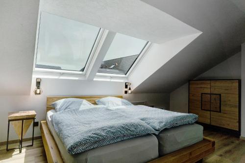a bedroom with a bed and two windows at Moderne offene Dachgeschoßwohnung in Linx