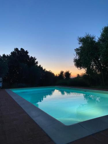 a swimming pool with a sunset in the background at Case Nell' Aia in Poggibonsi