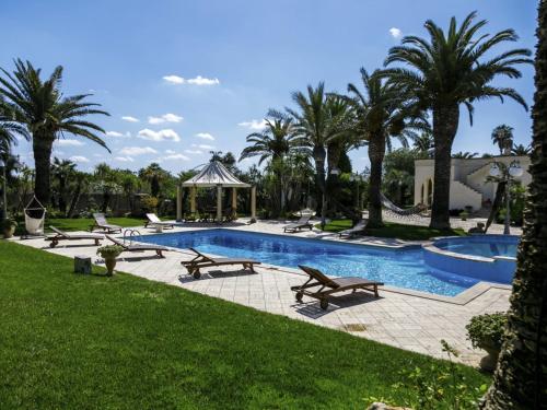 a swimming pool with benches and a gazebo at Villa Incoronata by Interhome in Nardò