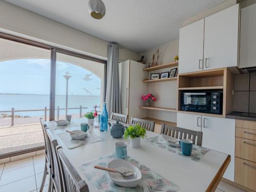 - une cuisine avec une table et une vue sur l'océan dans l'établissement Apartment Coudalère-Guadeloupe-3 by Interhome, au Barcarès