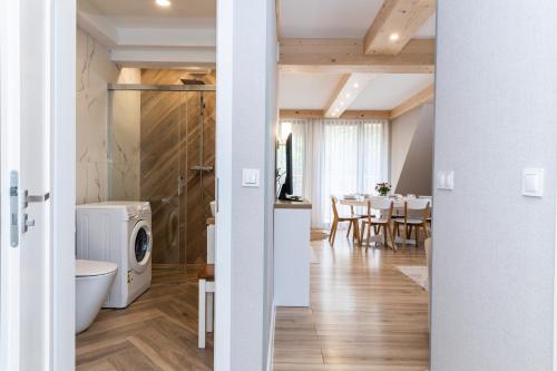 a kitchen and dining room with a washer and dryer at TatryTop Apartamenty Sabała in Zakopane