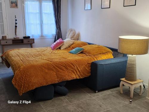 Cette chambre comprend un lit avec deux oreillers et une lampe. dans l'établissement le Côme-ci, comme ça, à Fécamp