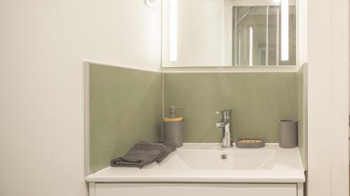 a bathroom with a sink and a mirror at BonAppart 2 - Charme Napoléonien & Confort in Troyes