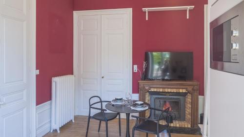 a dining room with a table and a fireplace at BonAppart 2 - Charme Napoléonien & Confort in Troyes