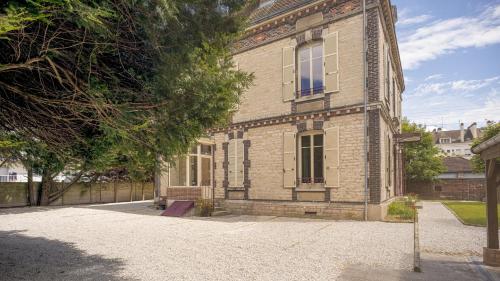 an old brick building with a tree in front of it at BonAppart 2 - Charme Napoléonien & Confort in Troyes