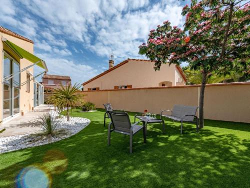 un patio avec deux chaises et une table dans une cour dans l'établissement Villa Ladine by Interhome, au Barcarès