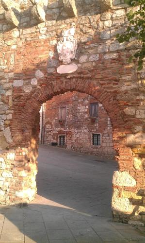 an archway in a brick building with a statue at Locanda Il Sigillo B&B e Ristorante in Rosignano Marittimo