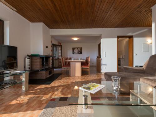 a living room with a couch and a table at Holiday Home Eifelnatur - Haus 1-4 by Interhome in Immerath