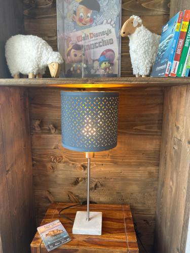 a lamp sitting on a table next to a book shelf at La Clé de Taulé in Taulé