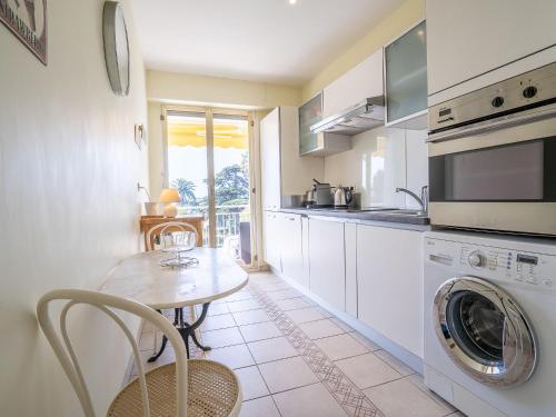 une cuisine avec une table et une machine à laver dans l'établissement Apartment Les Pervenches by Interhome, à Cannes