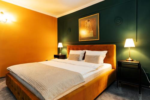 a bedroom with a large bed with green walls at Hotel Cocó in Timişoara